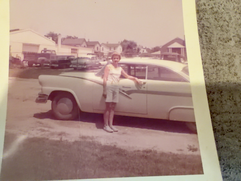 Viola Samuel standing beside a parked car.