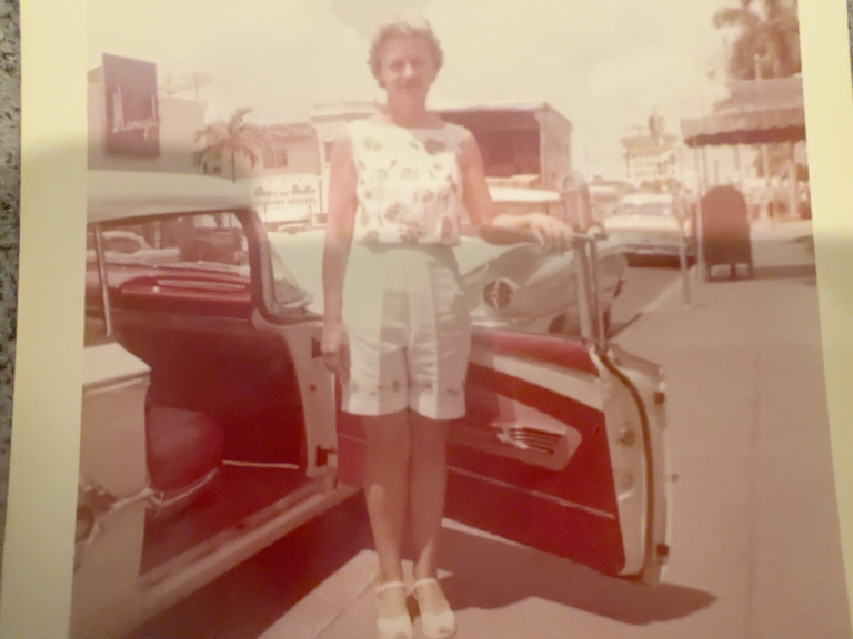 Viola Samuel standing beside an open car door.