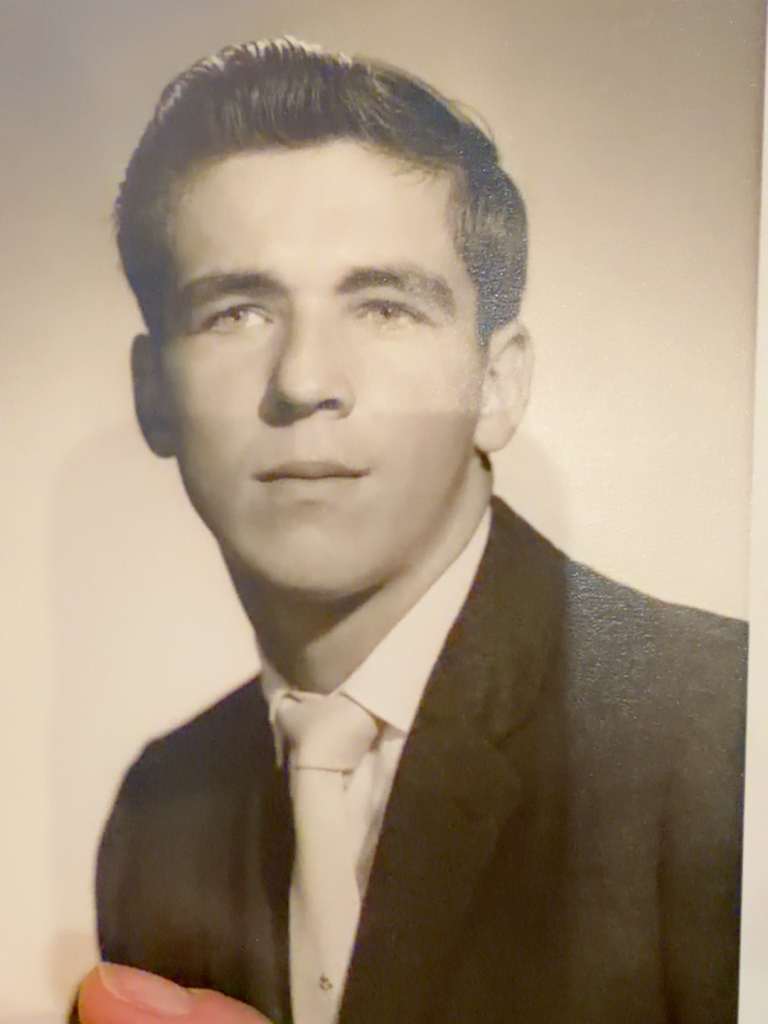 Studio portrait of Bob Samuel wearing a suit and tie.
