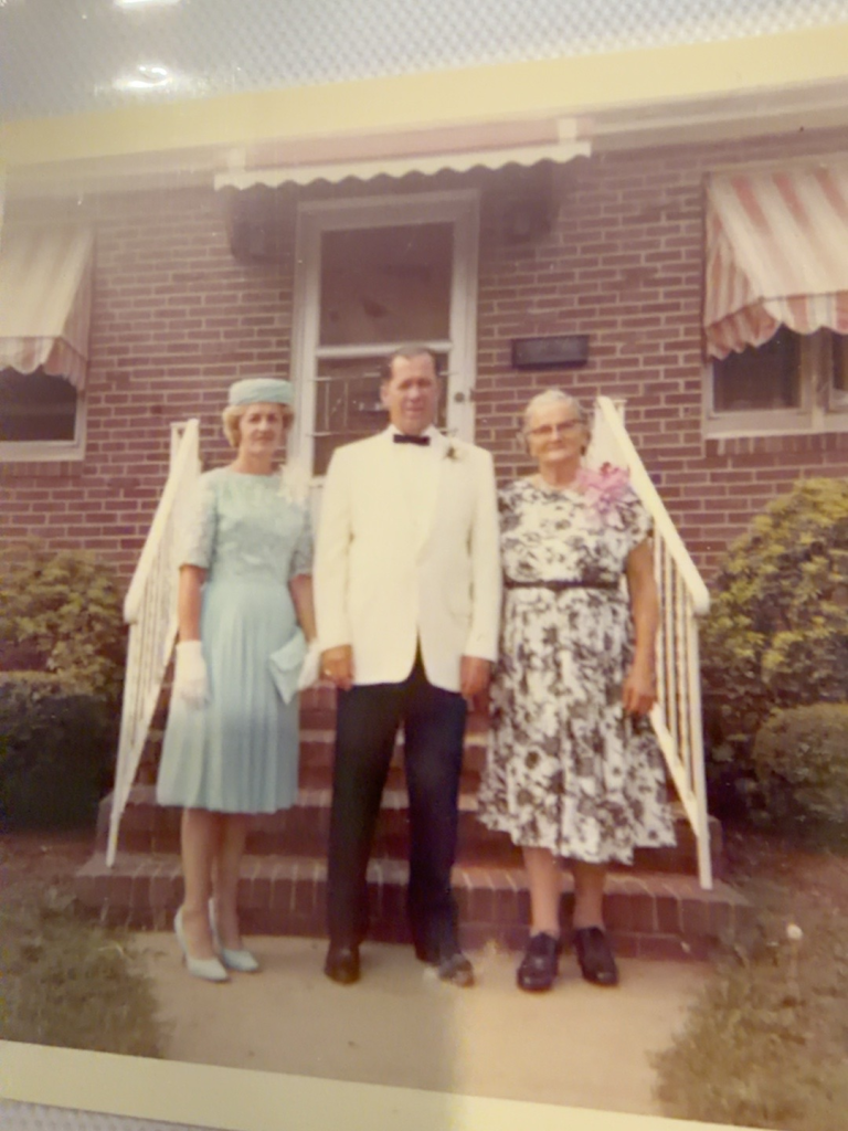 Viola and Frank Samuel with Mary Wistuba standing outside a house.