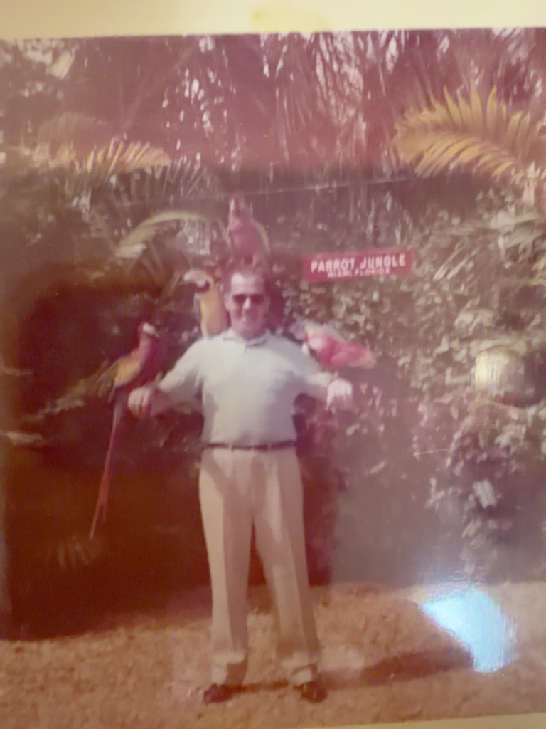 Frank Samuel standing outdoors beneath a Parrot Jungle sign.